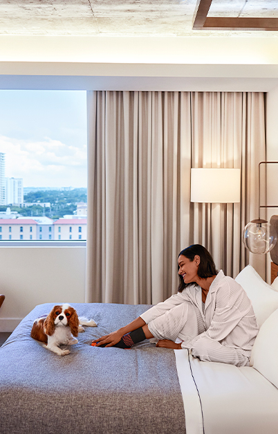 Woman sitting on the bed with a puppy